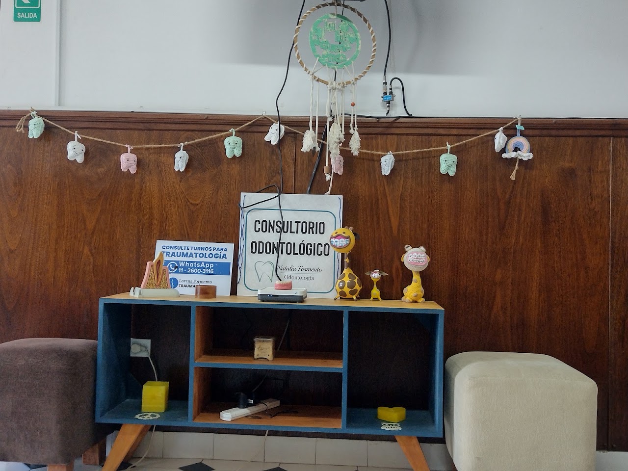 Instalaciones del consultorio de Natalia Formento Odontología en Castelar Norte, recepción moderna con madera cálida y área infantil